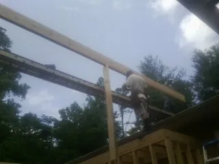 Carpenter setting a ridge beam over a new addition frame — Ice Dam Removal by Roofing Brothers in Discovery Bay