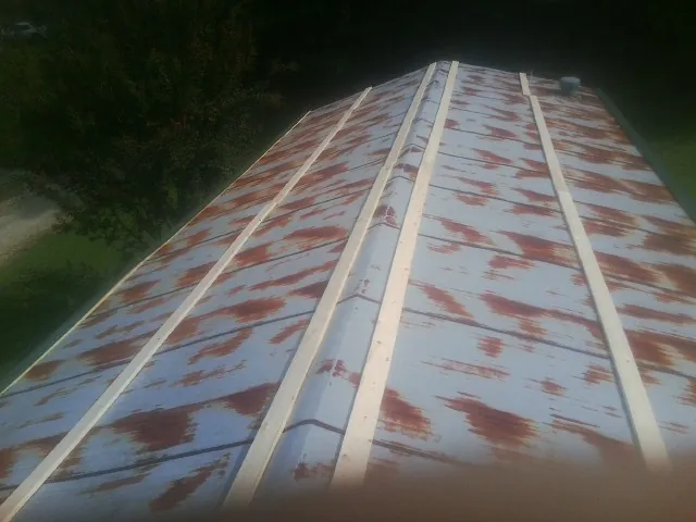 Rusted metal roof panels with new wood purlins before replacement — Storm Damage Roof Repair in Discovery Bay by Roofing Brothers