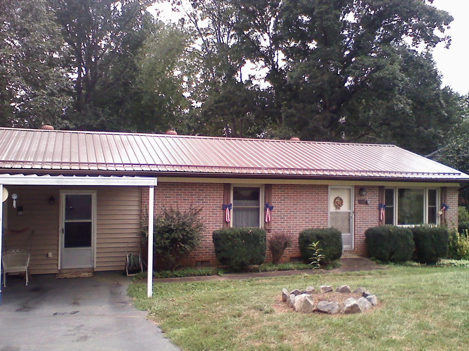 Bronze metal roof and carport on a brick ranch home — Roof Repair work by our crew in Discovery Bay